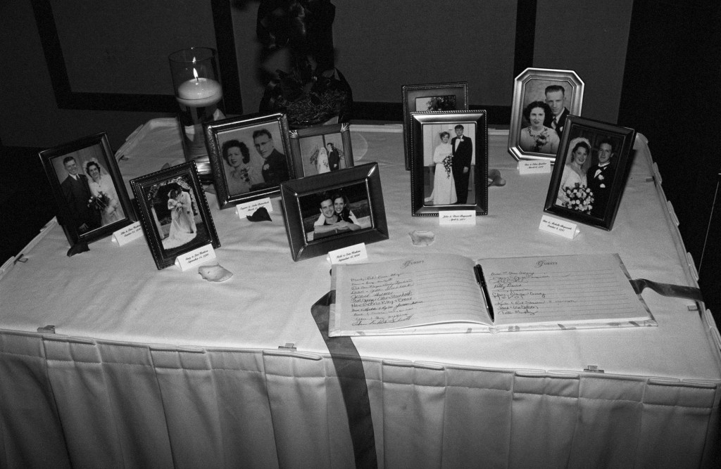 Family wedding picture display on guest book table.